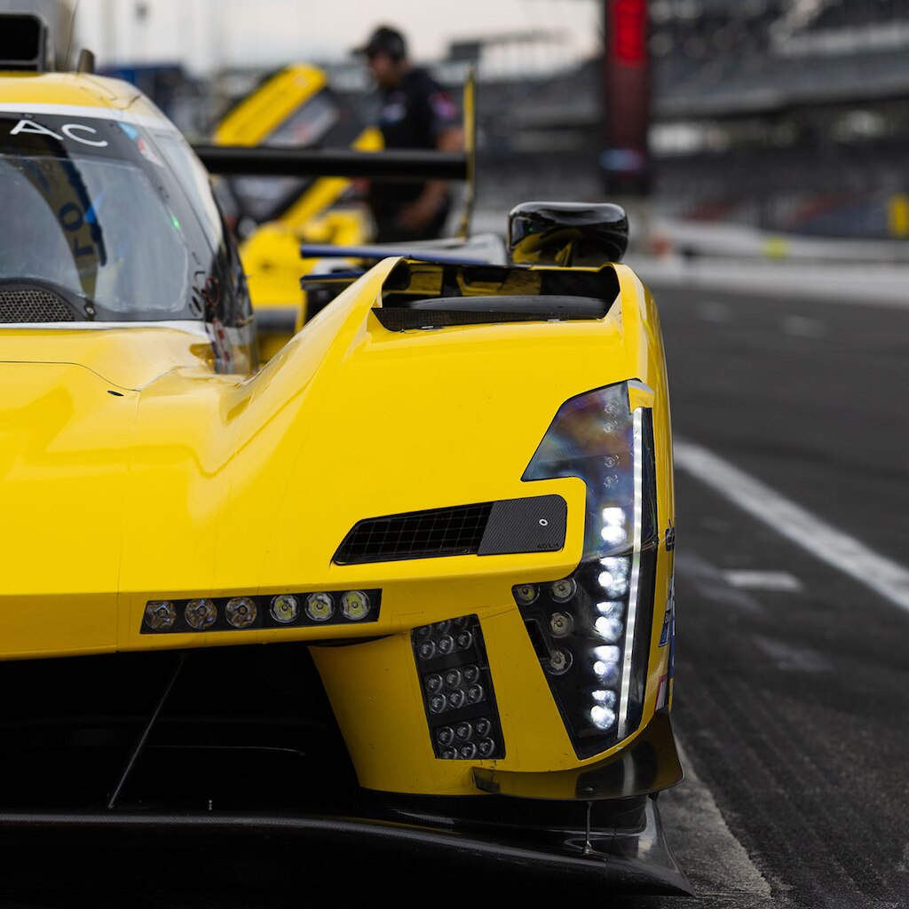 Autos de carrera Cadillac LMDh alineados en una pista