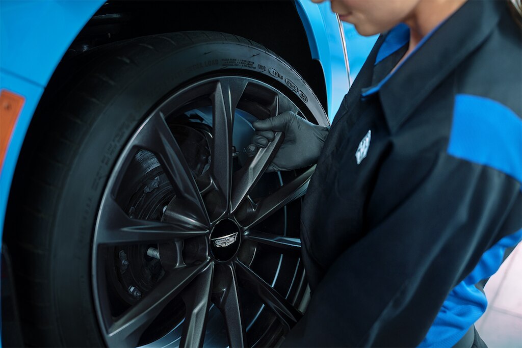 Un técnico de Cadillac instala un rin nuevo en un vehículo
