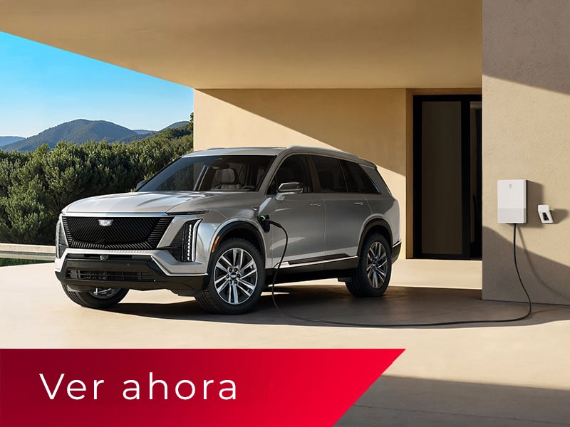 Vista de medio perfil de una Cadillac VISTIQ estacionada y cargándose en un cargador doméstico