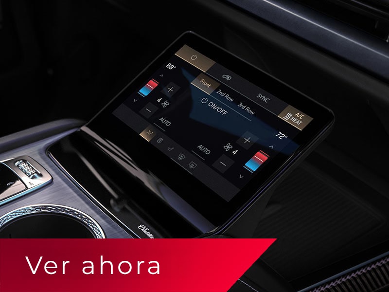 Primer plano de la consola central de una Cadillac VISTIQ 2027, que incluye los portavasos, la perilla de cambios y la pantalla de control de clima