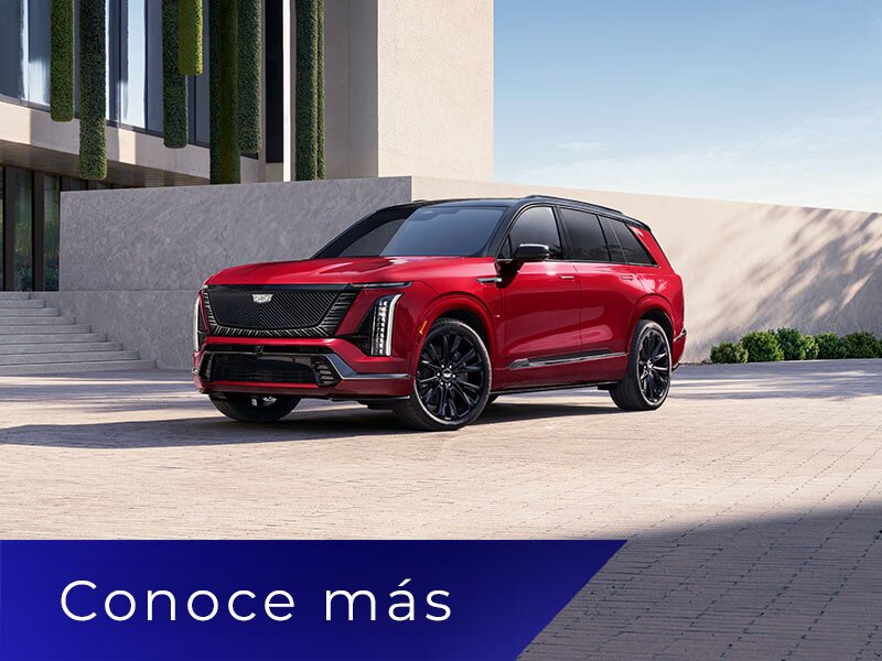 Vista de medio perfil de una SUV eléctrica VISTIQ 2027 de 3 filas estacionada junto a una pared de concreto