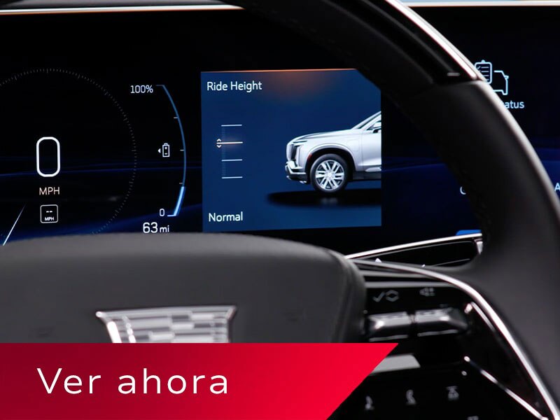 Primer plano del volante de una Cadillac VISTIQ y la pantalla de infoentretenimiento donde se muestra la característica Air Ride Adaptive Suspension
