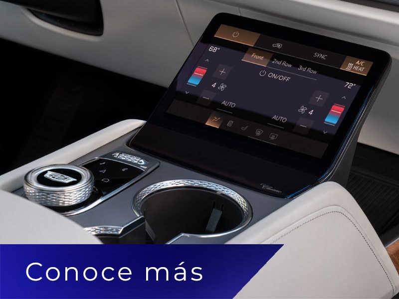 Primer plano de la consola central de una Cadillac VISTIQ con portavasos y una pantalla de control de clima