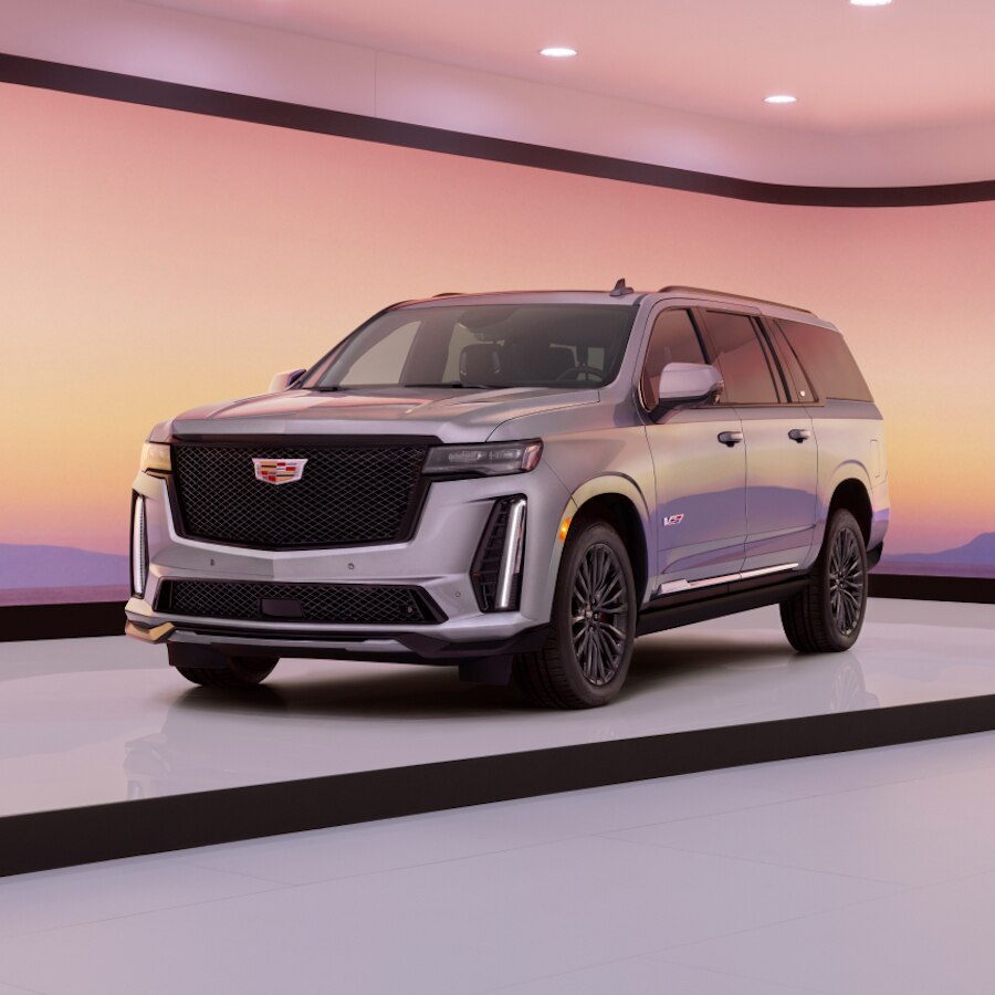Cadillac Escalade V 2023 estacionada sobre arena, con montañas sobresaliendo al fondo