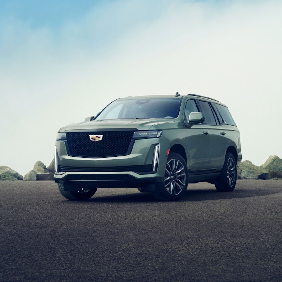 Cadillac Escalade 2023 estacionada sobre grava, con grandes rocas de fondo
