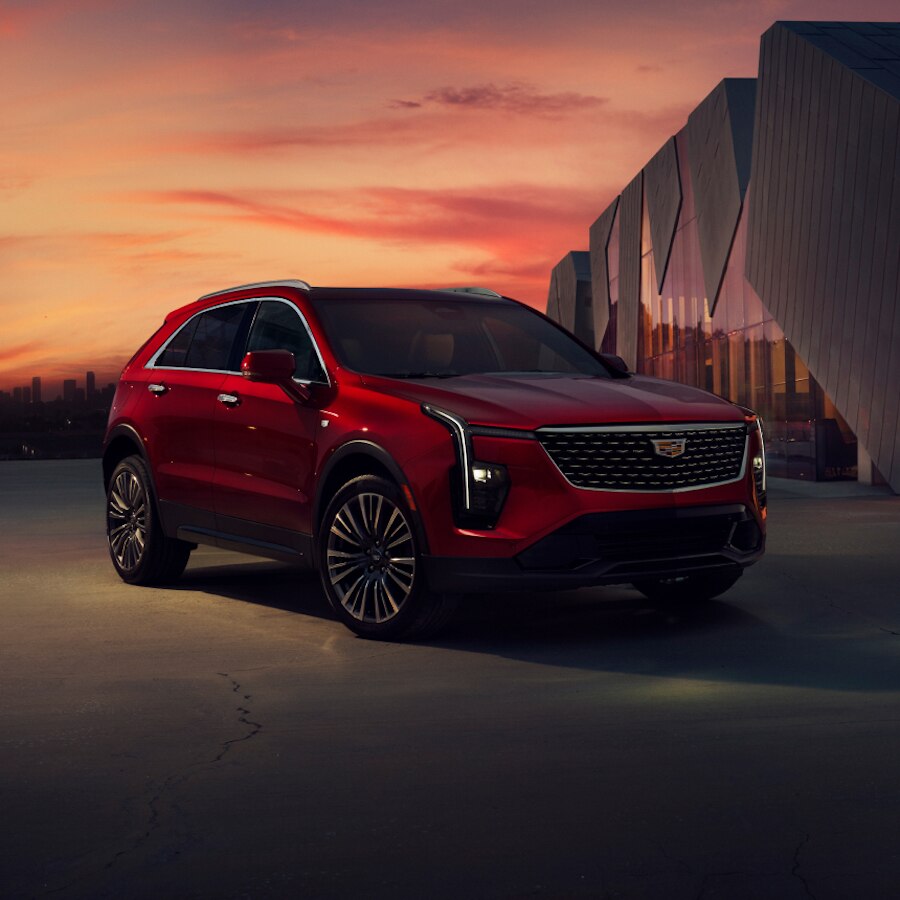 Cadillac XT4 2024 estacionado al anochecer, en frente de un edificio moderno