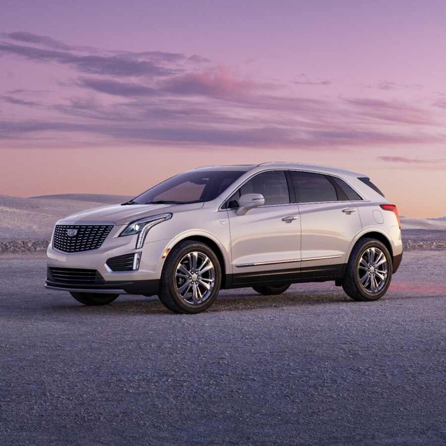 Cadillac XT5 2024 estacionado fuera de la carretera al anochecer, con montañas de fondo