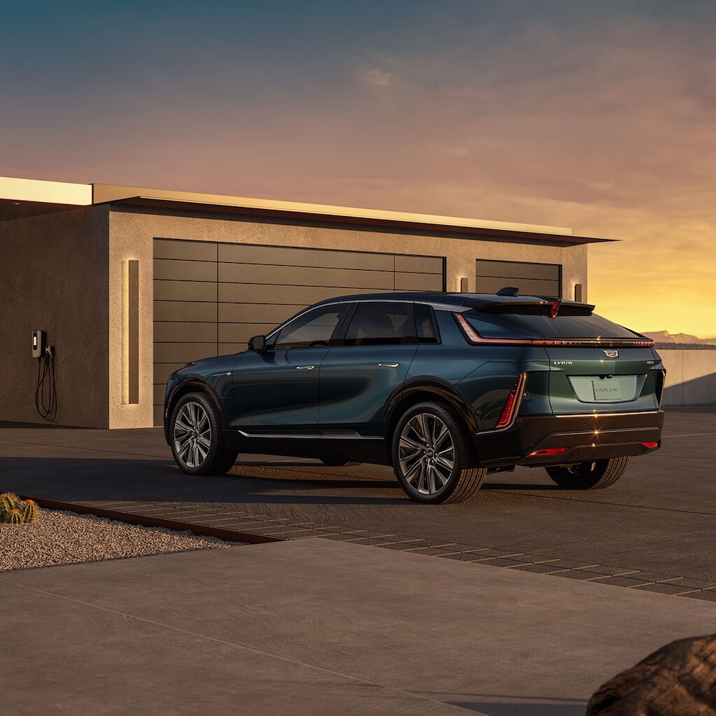 Cadillac LYRIQ estacionada frente a un garaje durante un hermoso atardecer